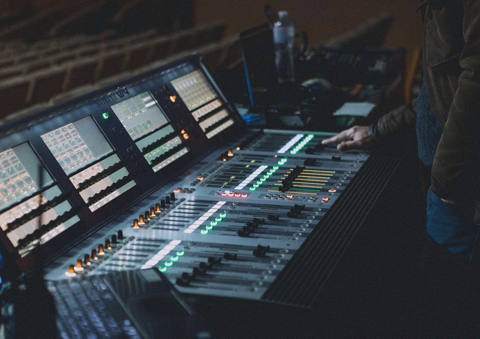 Sound engineer at a front-of-house console in a concert venue