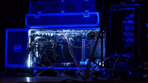 Rack de régie ouvert en salle, montrant le câblage de patch reliant la console au reste du système