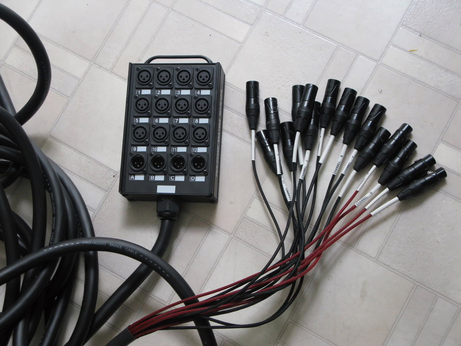 Stage box with twelve numbered XLR inputs, four returns and its multicore cable