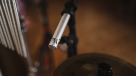 Un microphone placé au-dessus d'un kit de batterie en studio