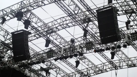 Système de diffusion avec caissons de basses et enceintes face au public lors d'un concert
