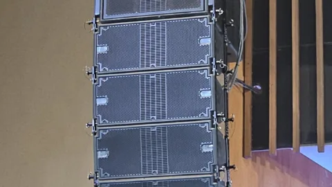 Système line array de sonorisation suspendu, vu de face pendant un concert