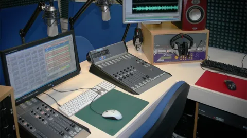Studio de radio avec console de mixage, micros et casques pour recevoir des invités