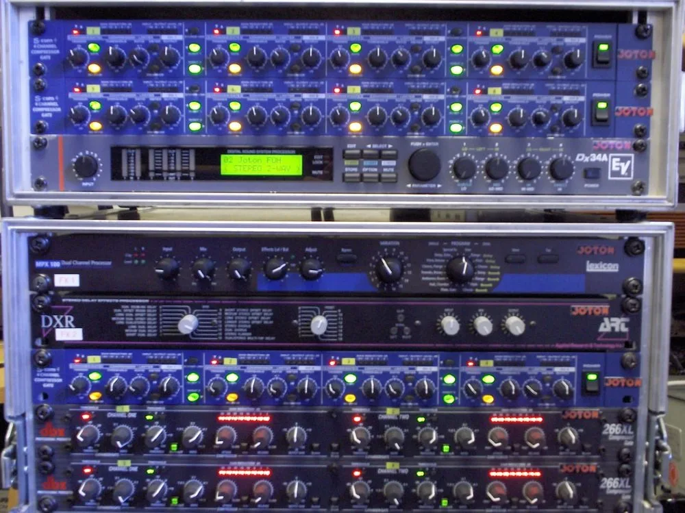 Front-of-house rack with amplifiers and system processors during a concert