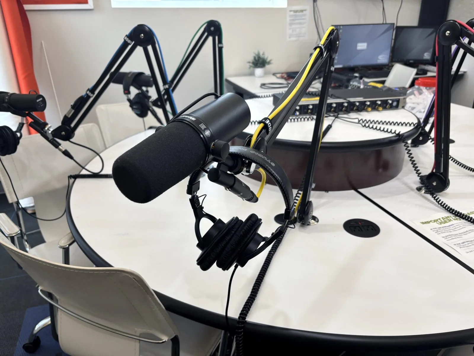 Table de prise de son d’un studio de podcast avec micros sur pied