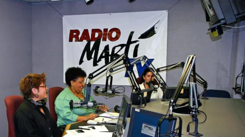 Studio de radio en self-op avec sa console de mise en onde, son micro et ses ecrans